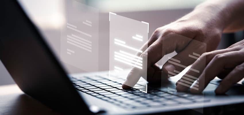 Plano cerrado de manos trabajando en computador organizando archivos con las herramientas de gestión documental implementadas con Legarchivo