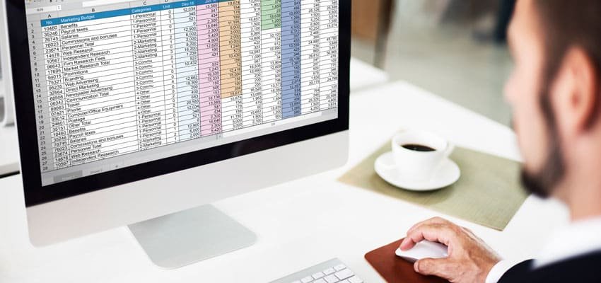 Persona implementado hojas de cálculo en computador mostrando los tipos de formatos de archivos digitales a implementar con Legarchivo
